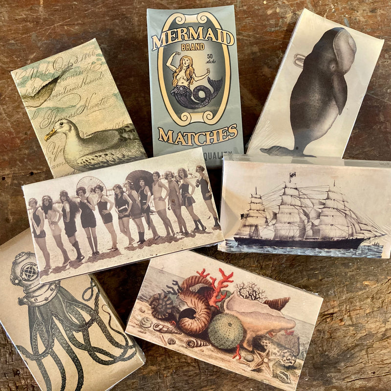 Luxury vintage style matchboxes with various designs, including nautical and coastal themes. Wooden matches with colored tips, Rockport Candle Company